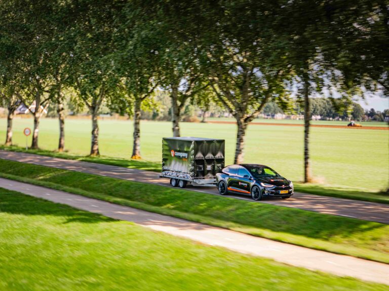 Tesla met aanhanger foto vanaf rechtsvoor